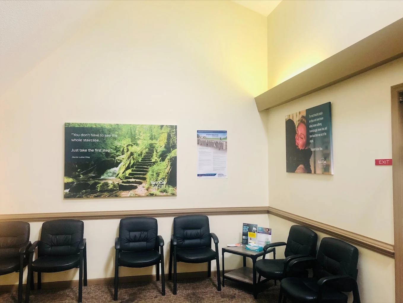 Waiting room with chairs, table, and wall posters