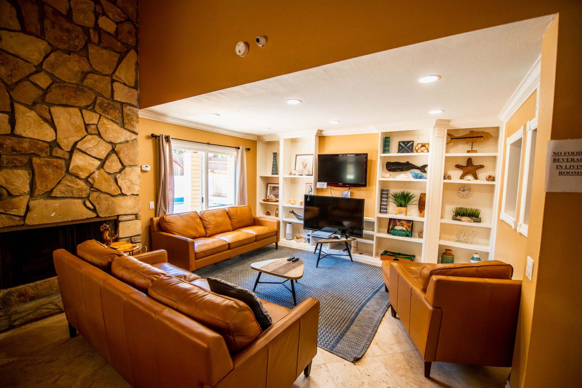 Lounge with TVs, couches, and built-in shelves