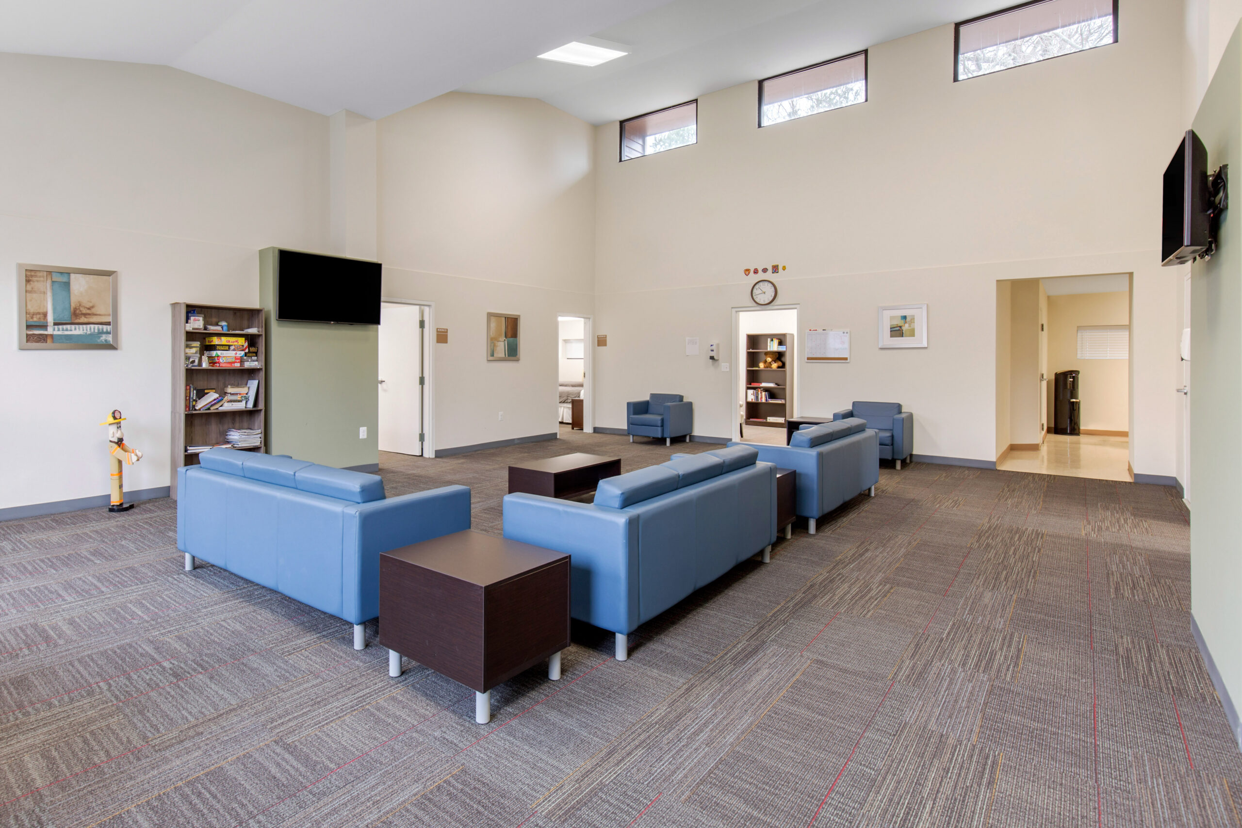 Lounge with blue sofas and wall-mounted TV