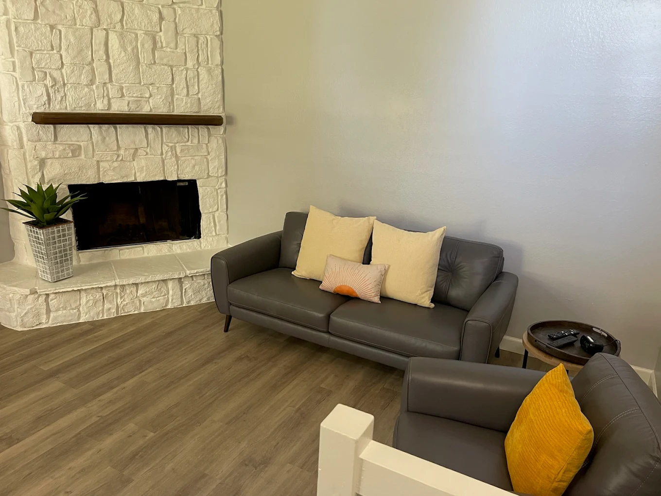White brick fireplace with gray sofa and pillows