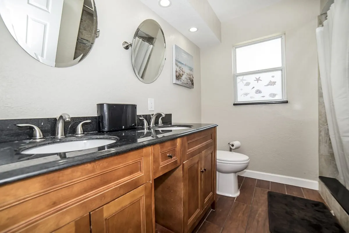 Double sink bathroom with mirrors and wood cabinets