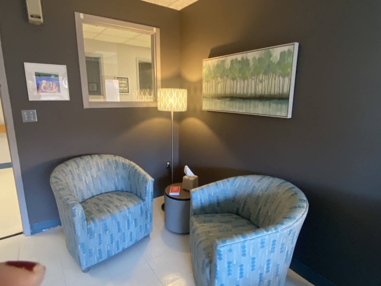 Cozy corner with two chairs, lamp, and wall art