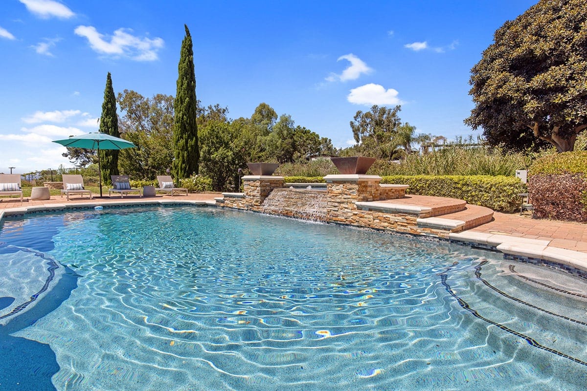 Outdoor swimming pool with lounge chairs and landscaped surroundings