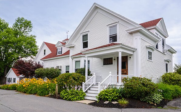 White two-story rehab center with garden and walkway