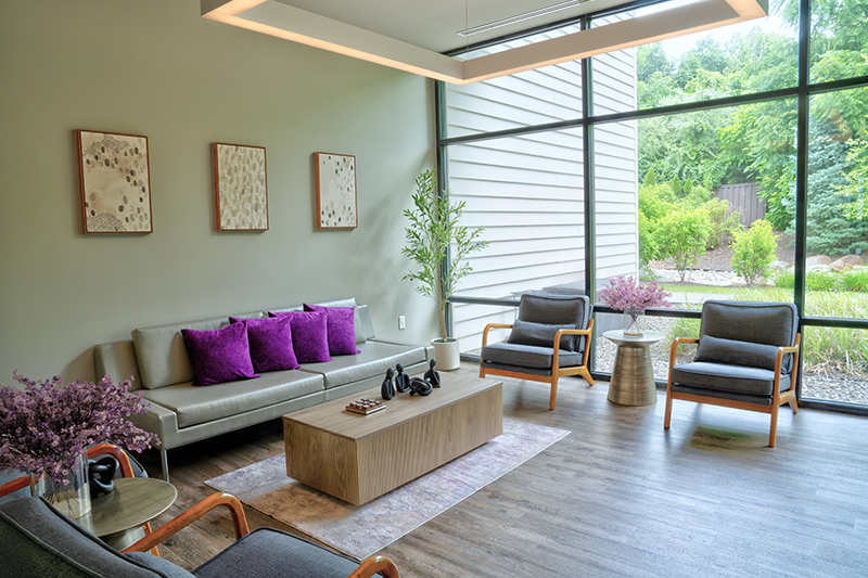 Modern lounge with sofa and chairs by large windows