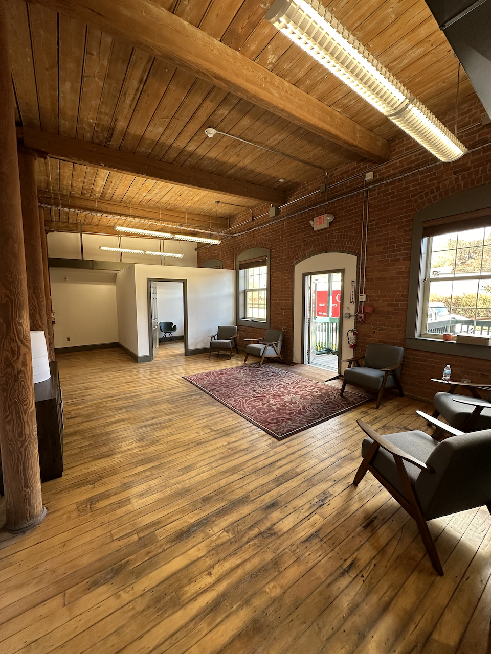 Waiting area with modern chairs, large windows, and hardwood floors