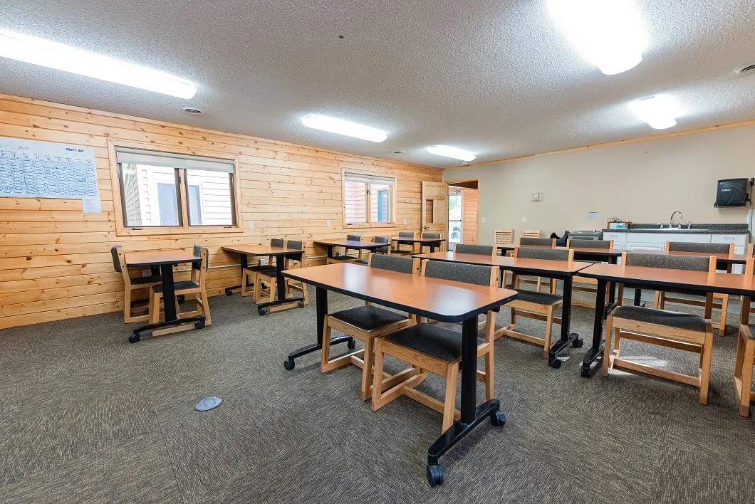 Classroom with tables, chairs, and presentation space