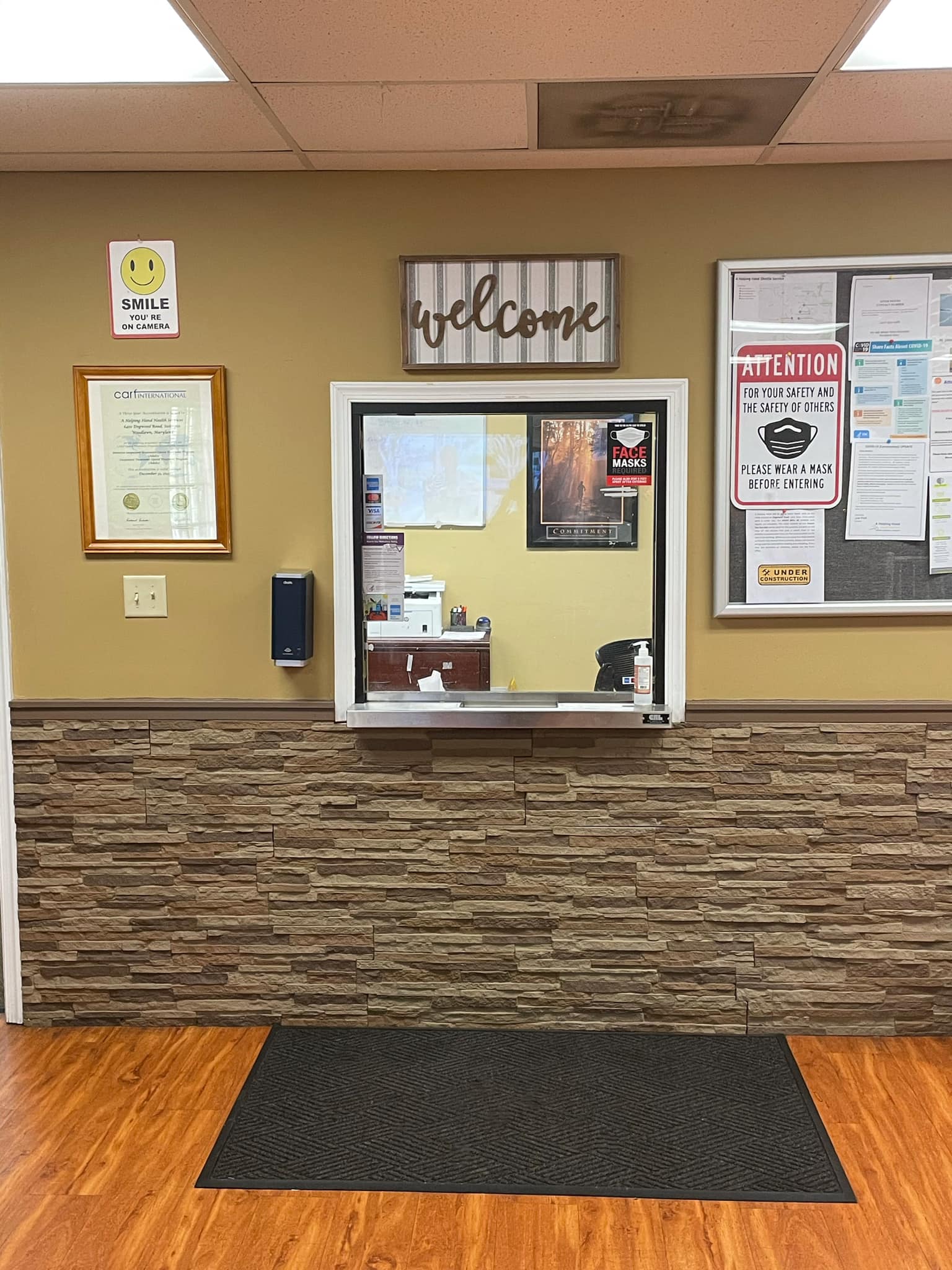 Interior reception window with welcome sign and wall notices