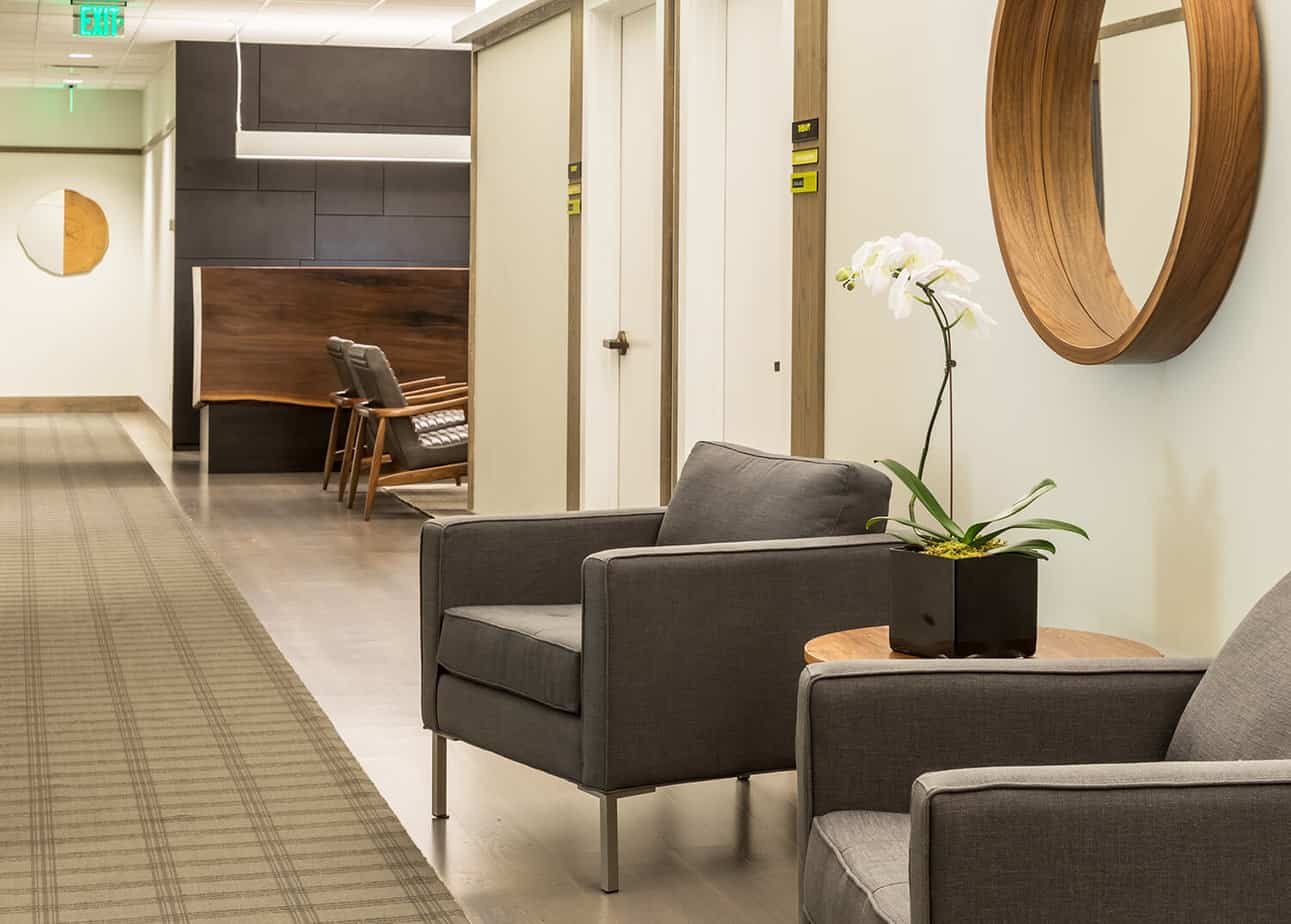 Gray chairs and orchid near treatment room doors