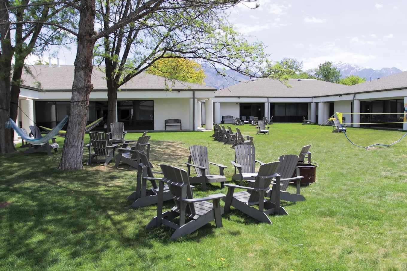Outdoor lawn with Adirondack chairs and mountain views.