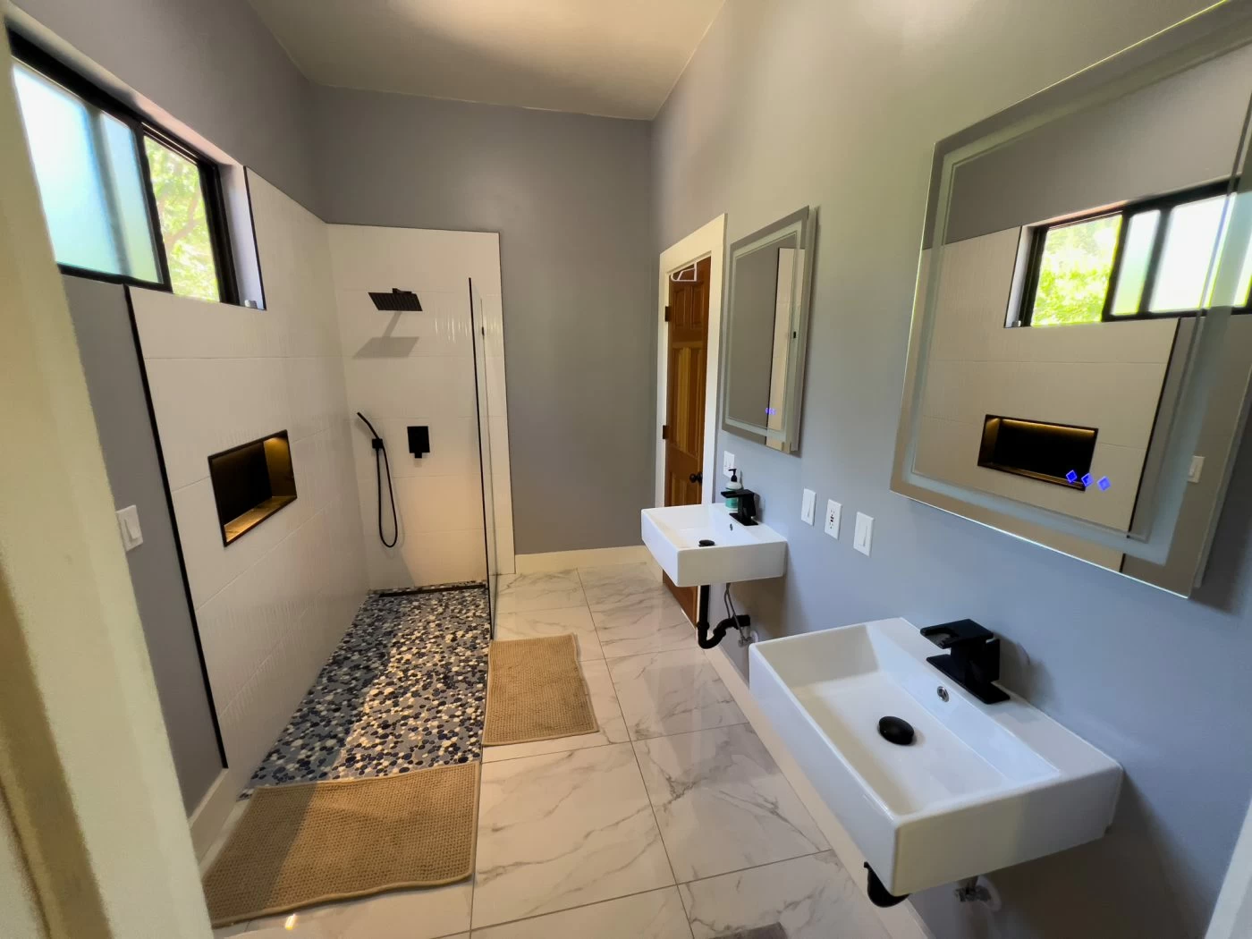 Bathroom with dual sinks and walk-in shower