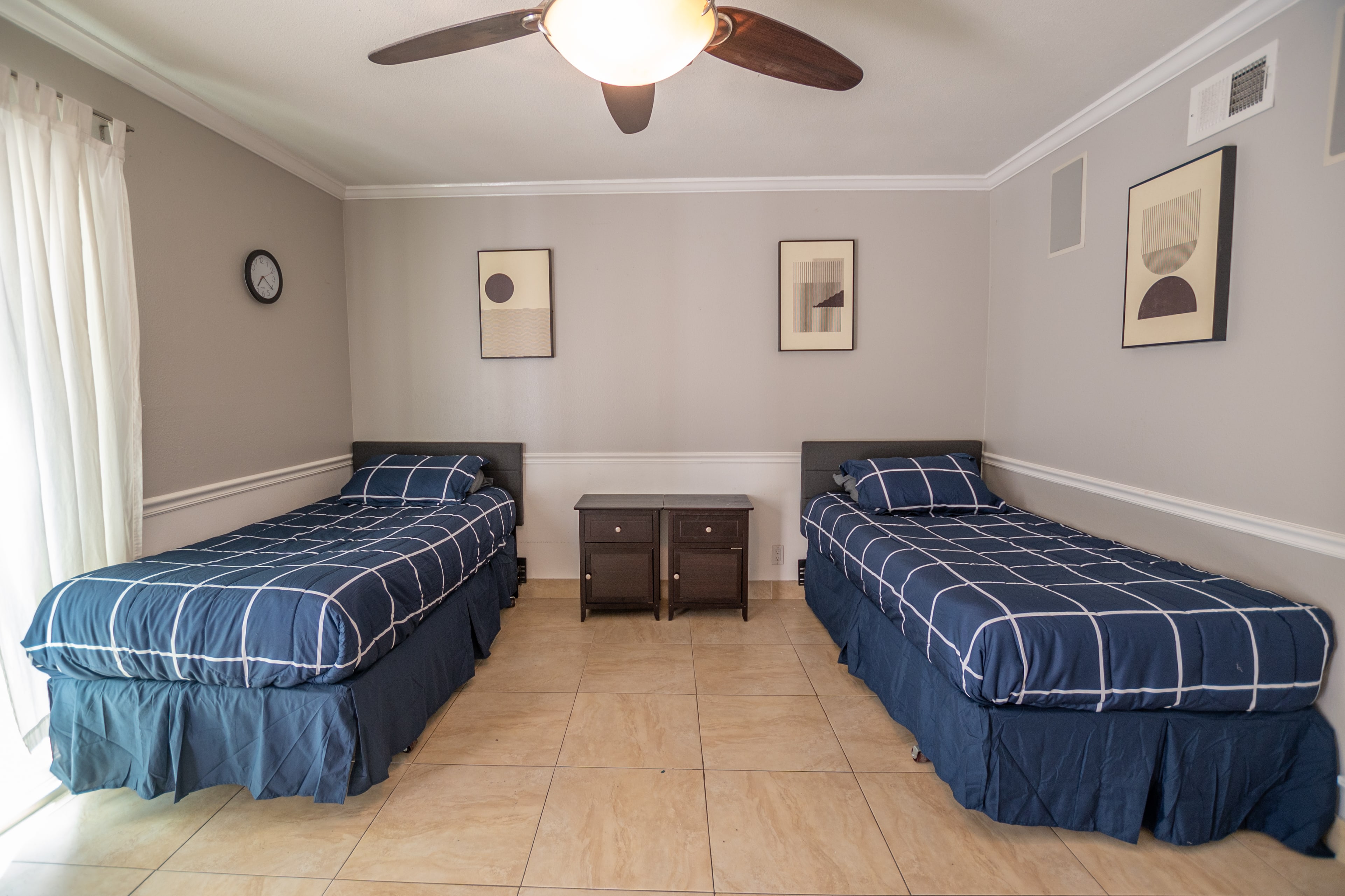 Twin beds with checkered bedding in shared bedroom