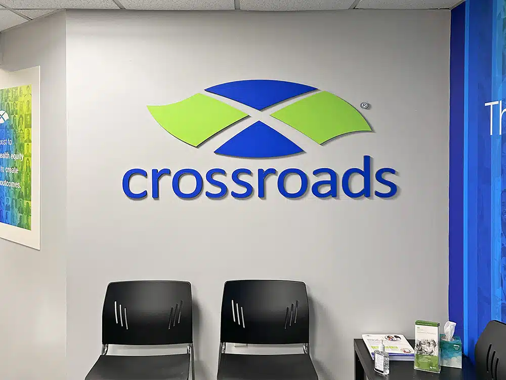 Waiting chairs beneath Crossroads logo on wall
