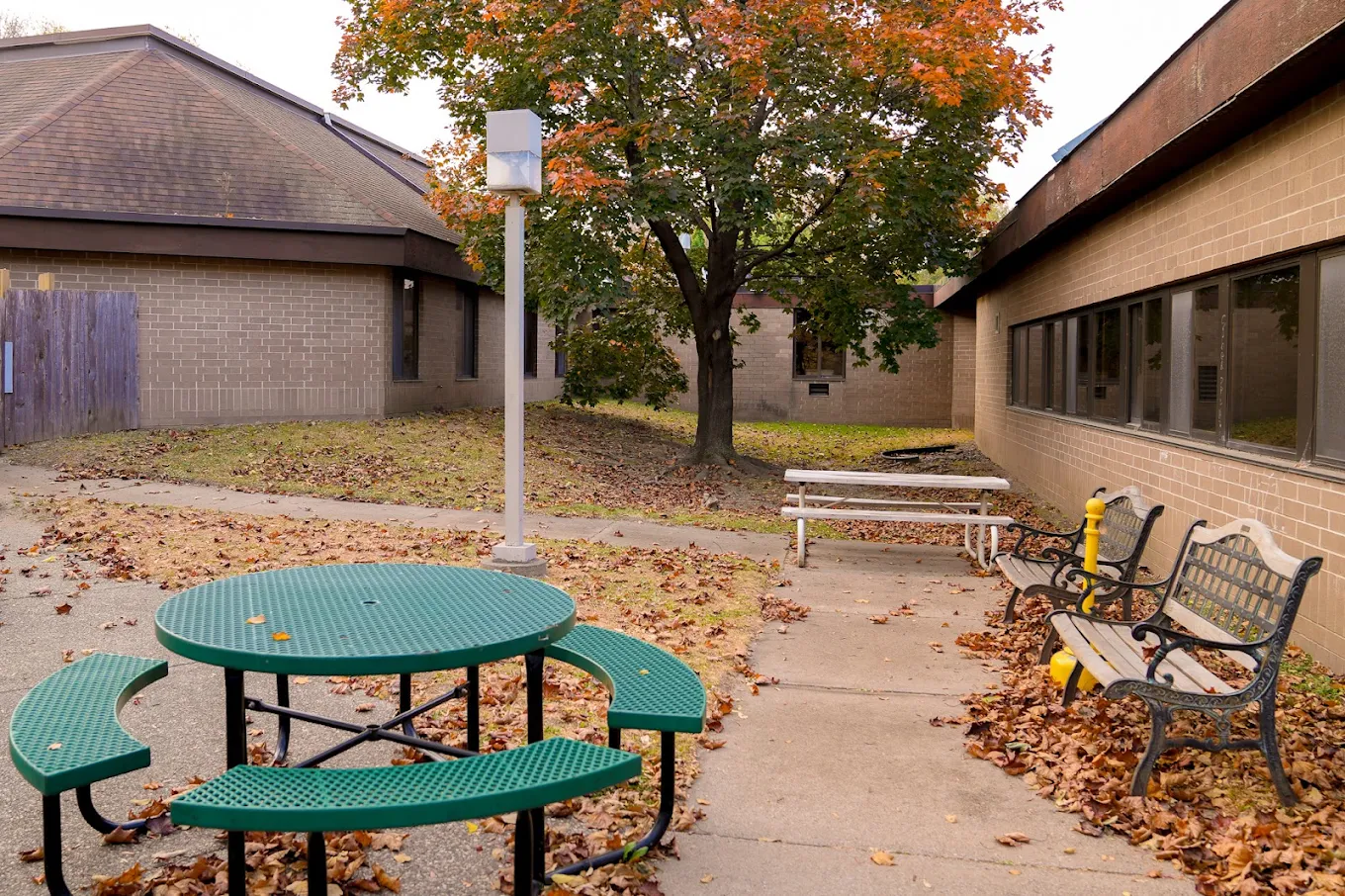 Outdoor courtyard with benches and picnic tables at EOSIS Tapestry
