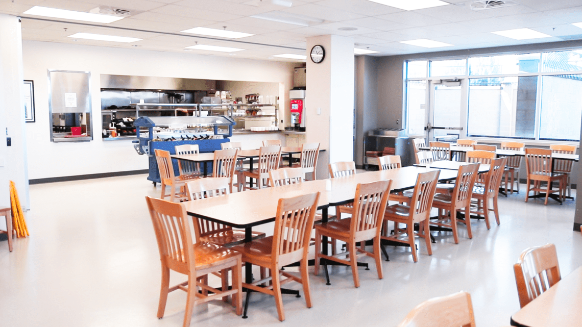 Bright dining area with wooden tables and food service counter