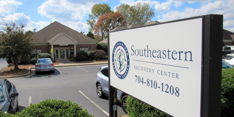 A bright, welcoming exterior of Southeastern Recovery Center, with a clear sign in the foreground and a well-maintained building surrounded by greenery.