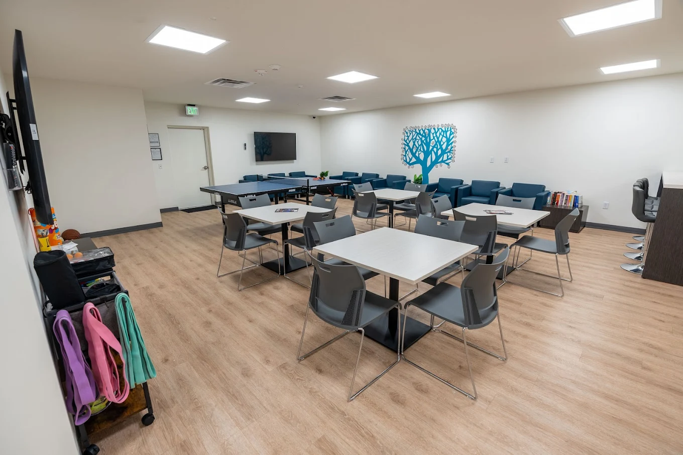Group room with tables, chairs, and lounge area