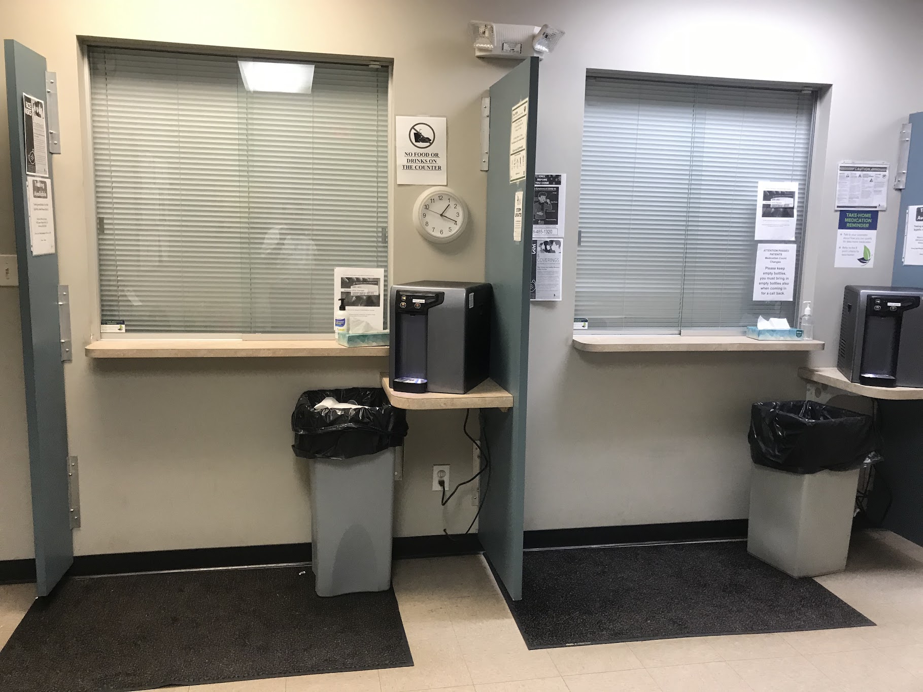 Two service windows with blinds and water dispenser between them