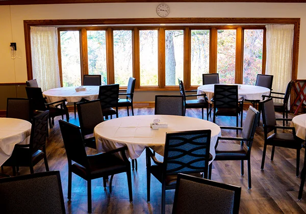 Dining room with round tables and large windows at Beauterre