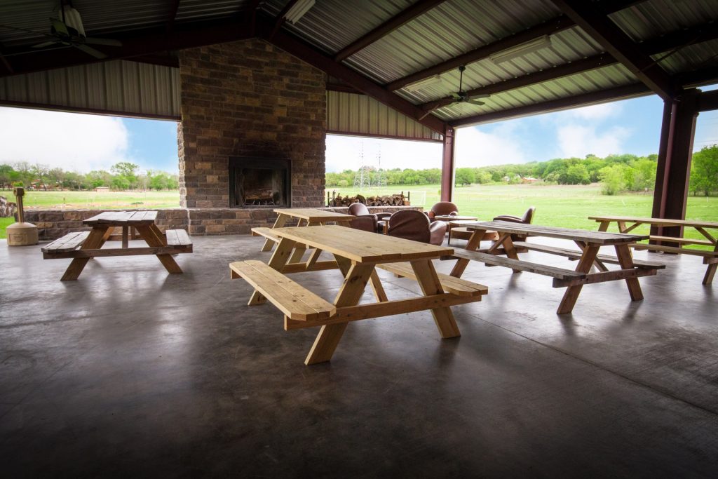 Picnic tables under pavilion with fireplace