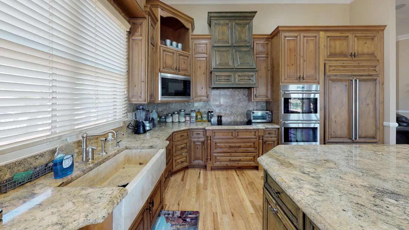 Kitchen with wood cabinetry, granite counters, and appliances