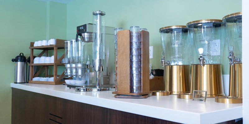 A well-organized beverage station with elegant drink dispensers and a coffee setup, offering a refreshing break in a serene setting.