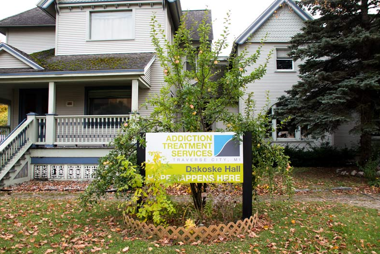 Two-story rehab house with front porch and facility sign