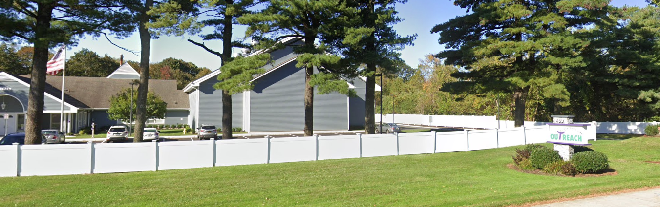 Outreach sign and main entrance view with greenery