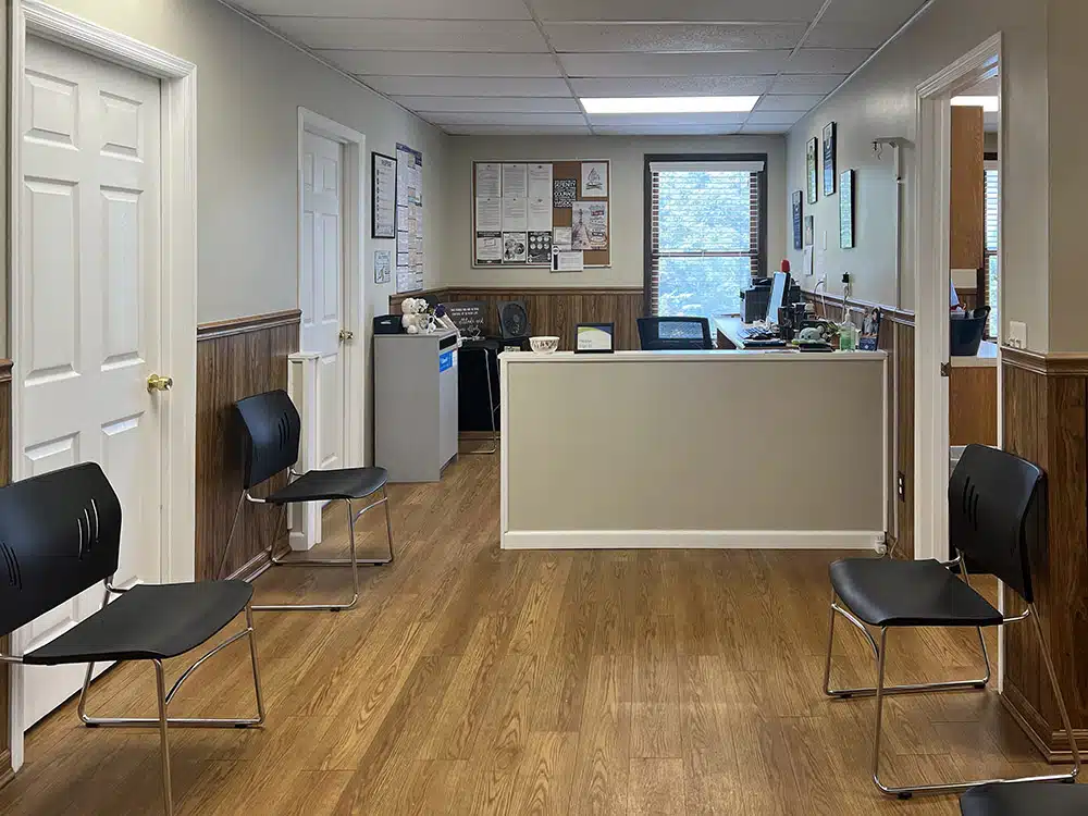 Front desk with chairs in hallway waiting area
