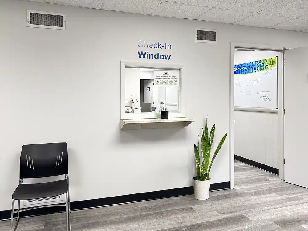 Check-in window with counter and nearby chair and plant