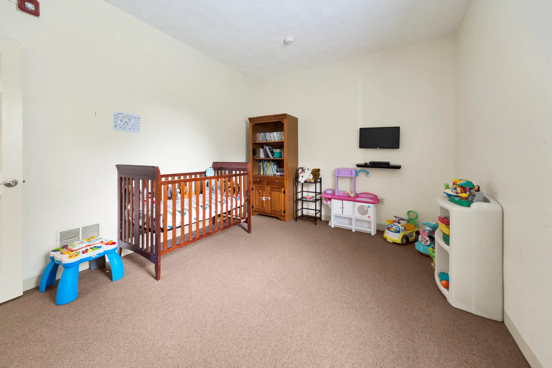 Nursery room with crib, toys, and child play area