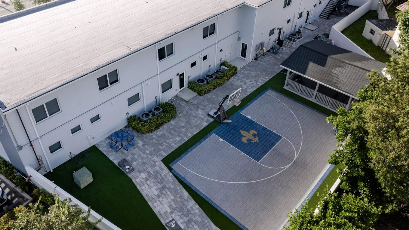 Aerial view with a basketball court and shaded seating area.