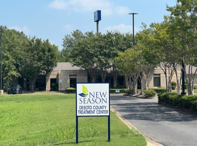Clinic sign and building seen from tree-lined driveway