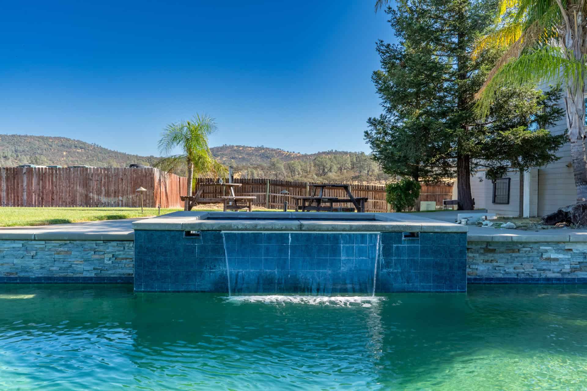Pool with waterfall feature and landscaped yard