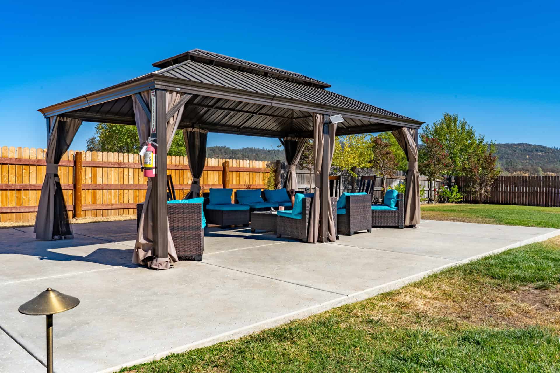 Gazebo with cushioned seating in fenced outdoor area