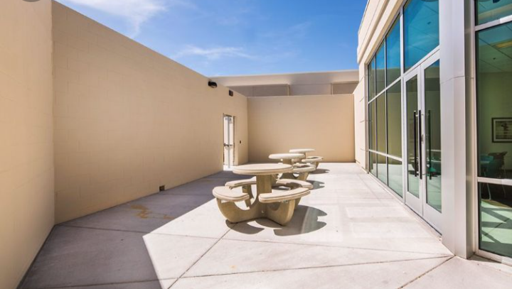 Secure outdoor patio with picnic tables and seating area