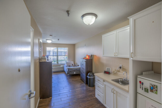 Shared recovery room with bed, dresser, and kitchenette