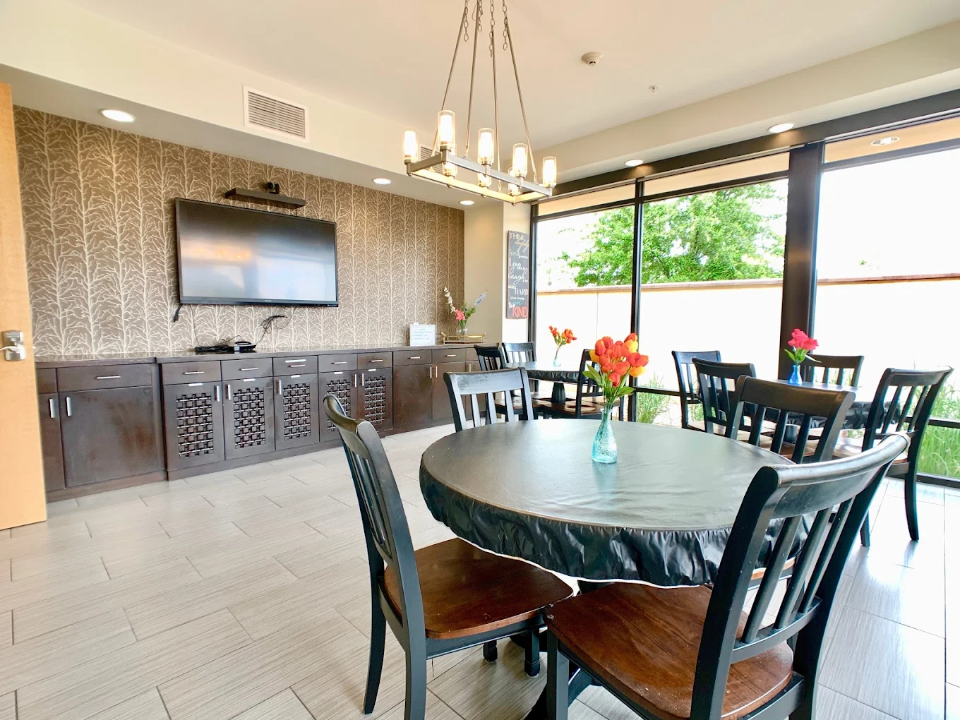 Dining room with tables, chairs, and mounted TV