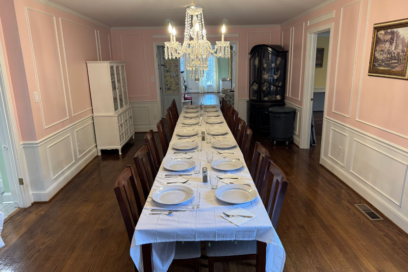 Long table set for meal under a crystal chandelier