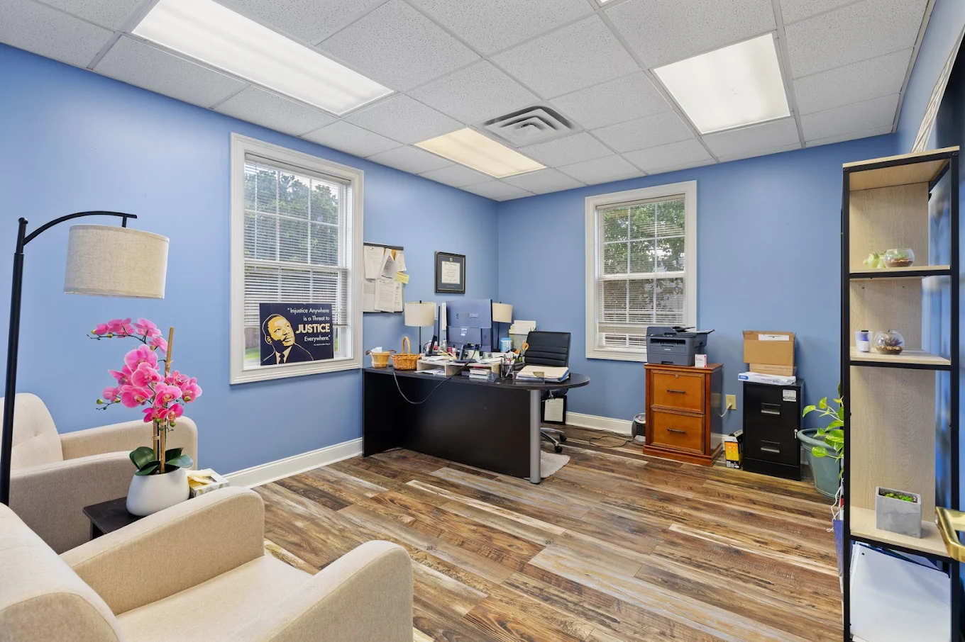 Private clinician office with desk, seating, and large windows
