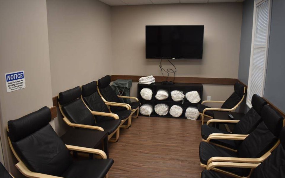 Waiting room with chairs, TV, and blanket storage