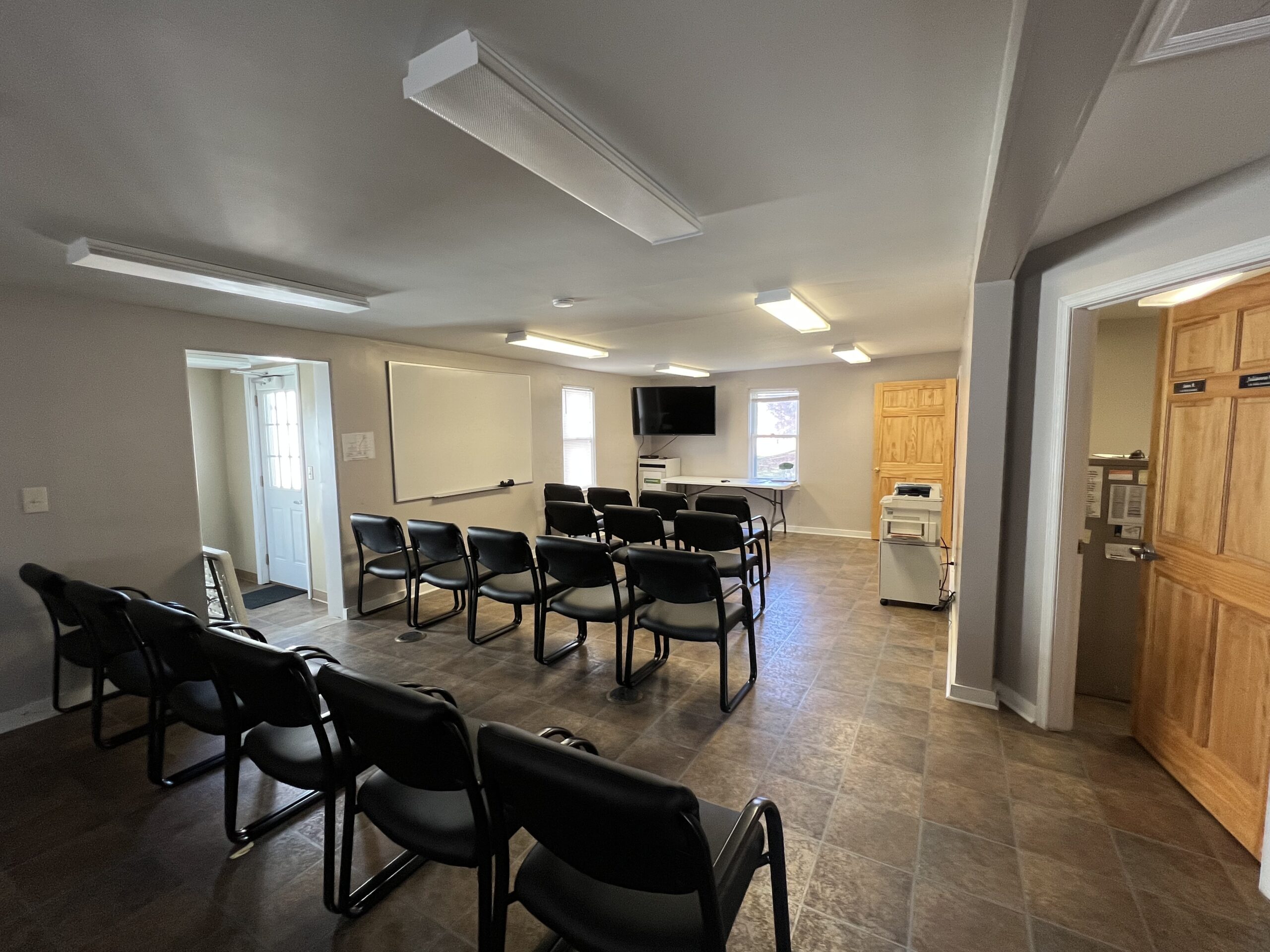 Rows of chairs facing whiteboard and wall-mounted TV