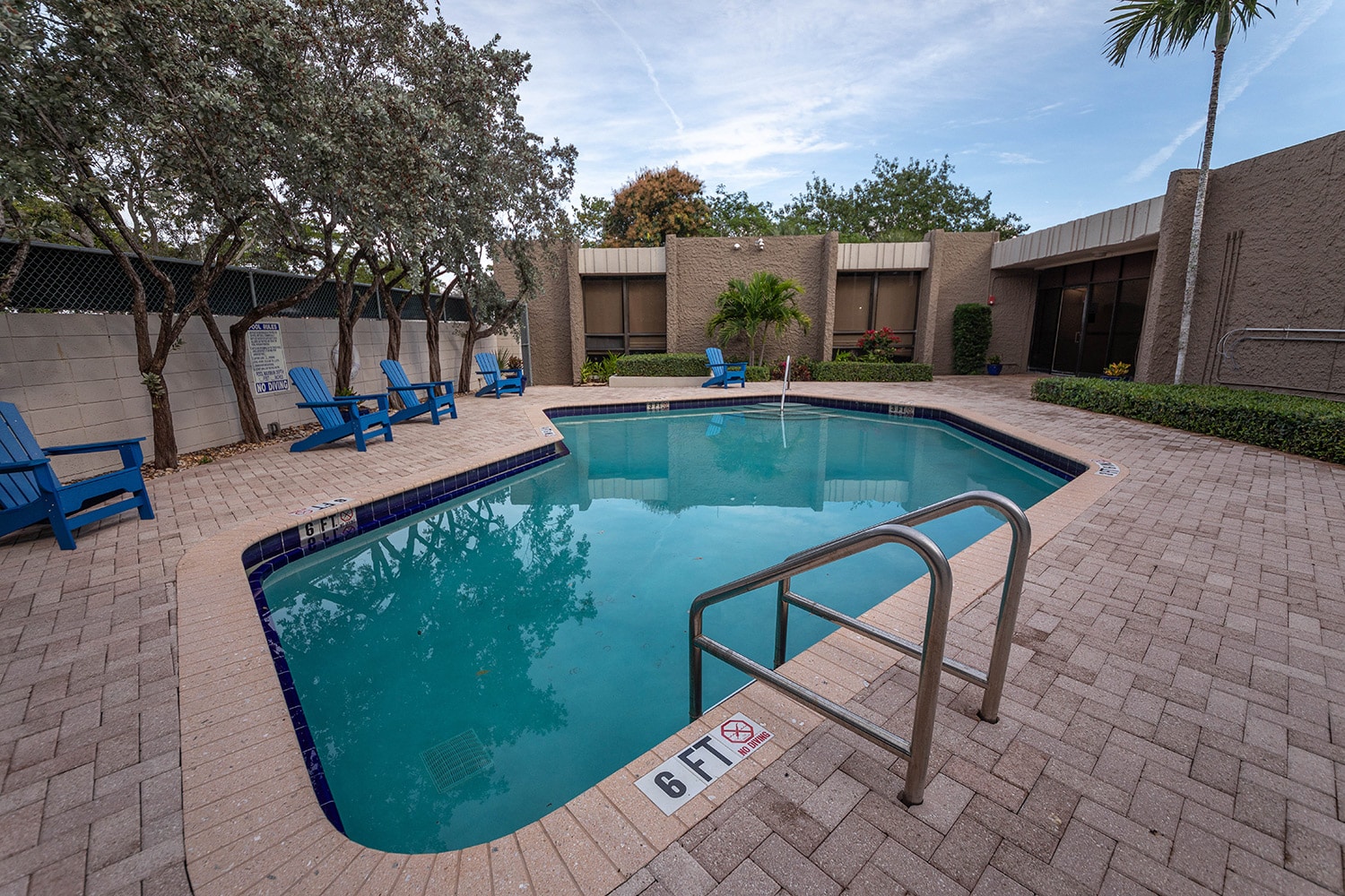 Outdoor pool with lounge chairs and privacy wall