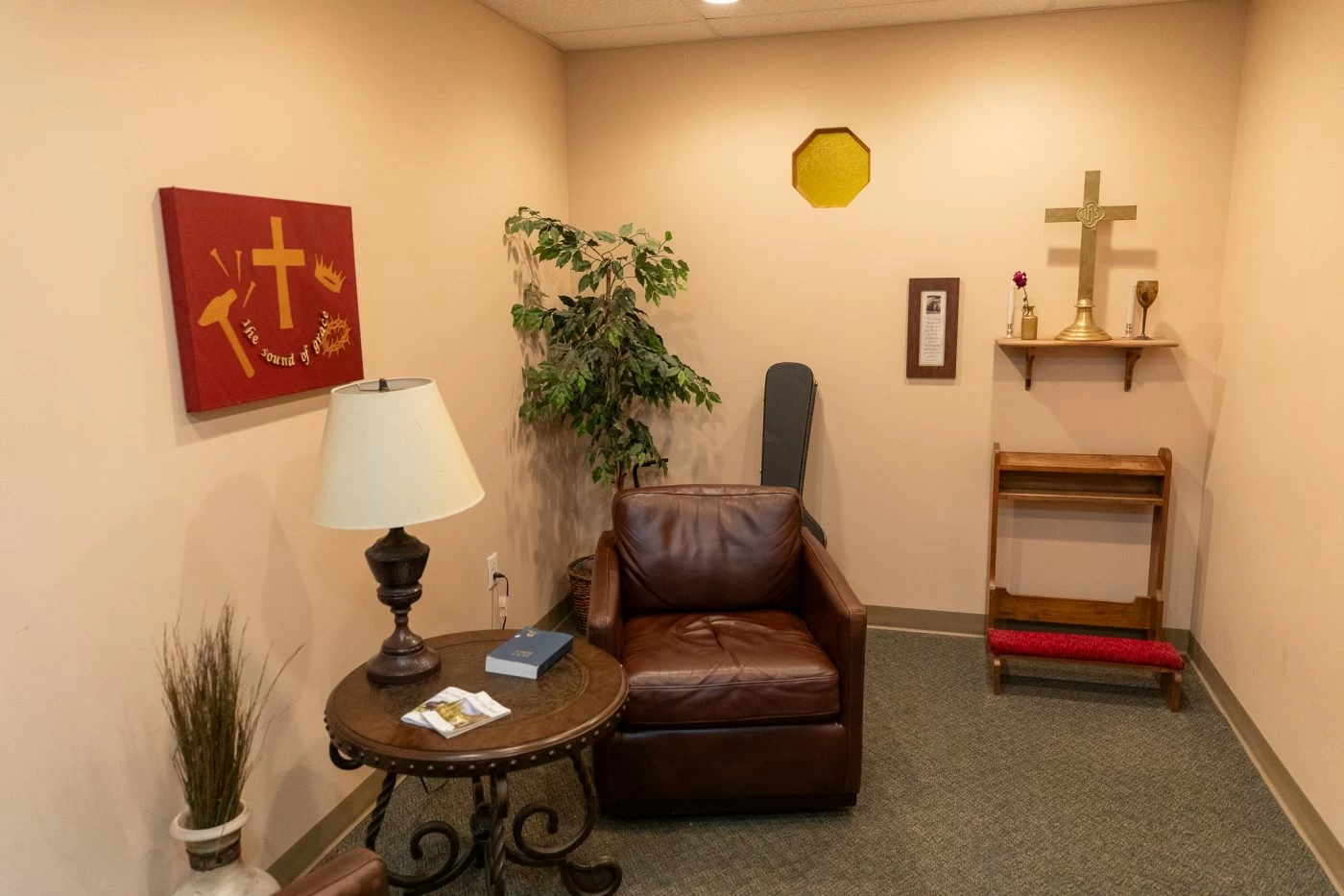 Small chapel-style room with chair, cross, table, and peaceful decor inside recovery center