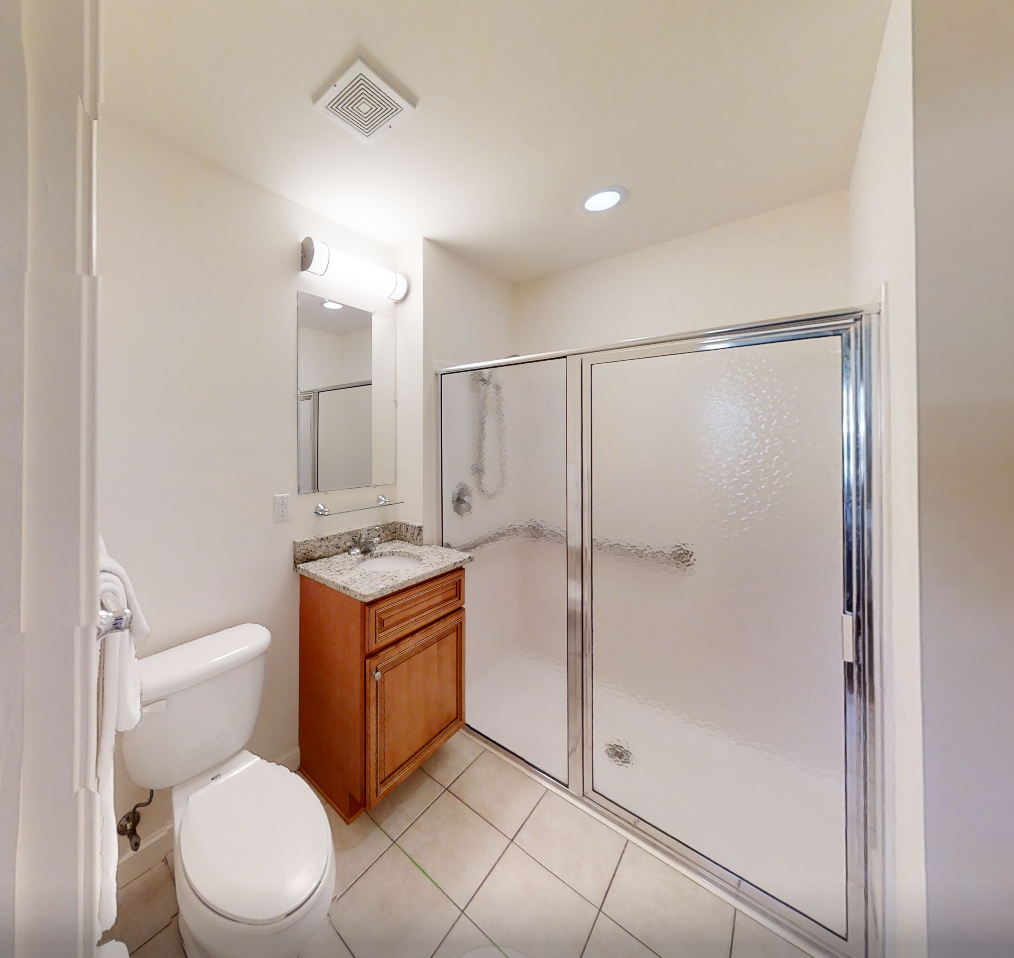 Clean private bathroom with shower and granite sink