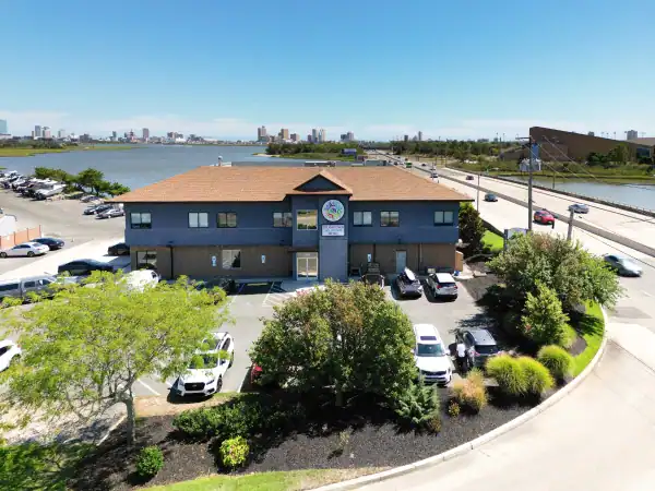 Aerial view of facility near water with parking lot