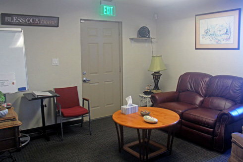 Cozy counseling room with sofa, chairs, and round wooden table