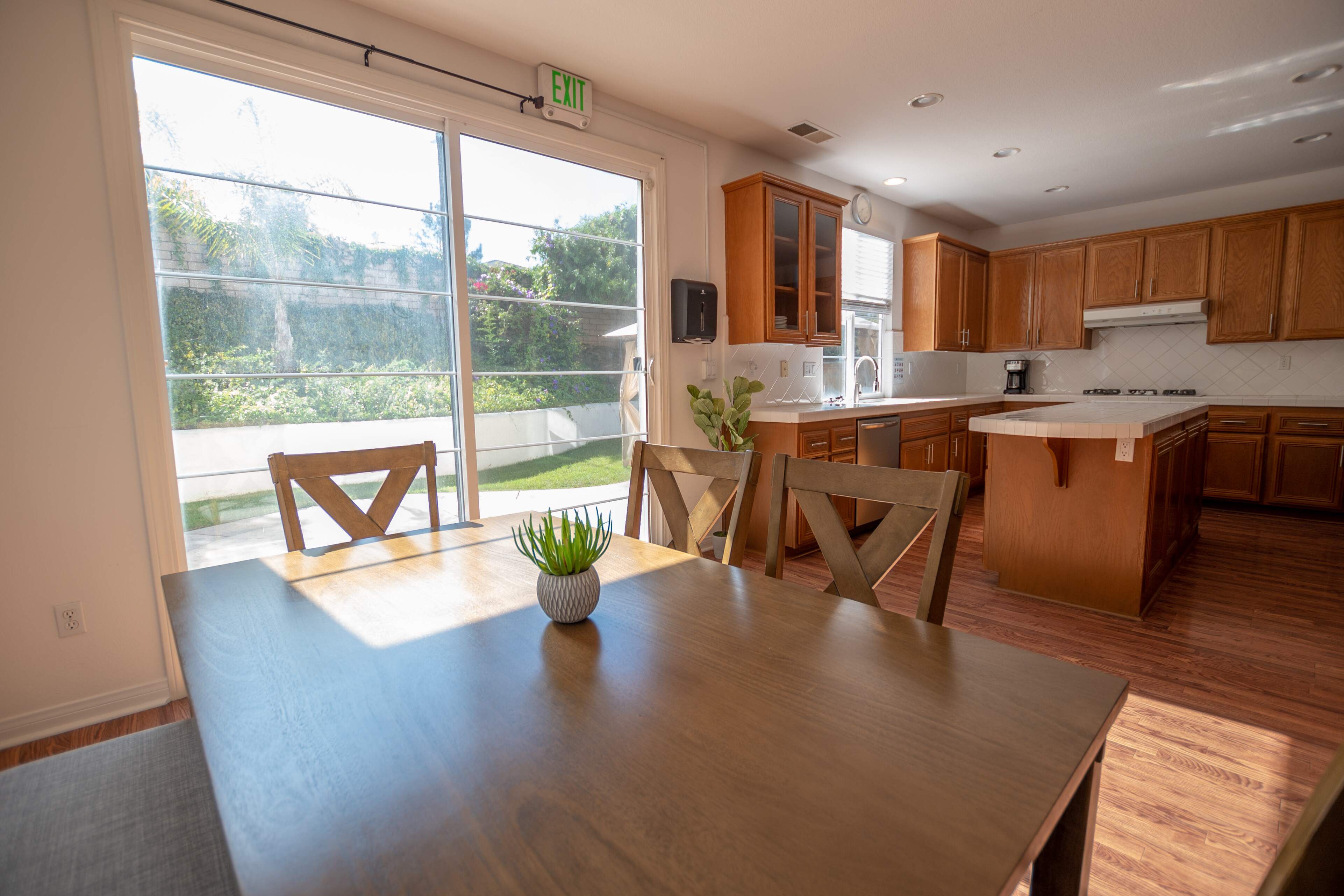 Wooden dining table next to a bright open kitchen