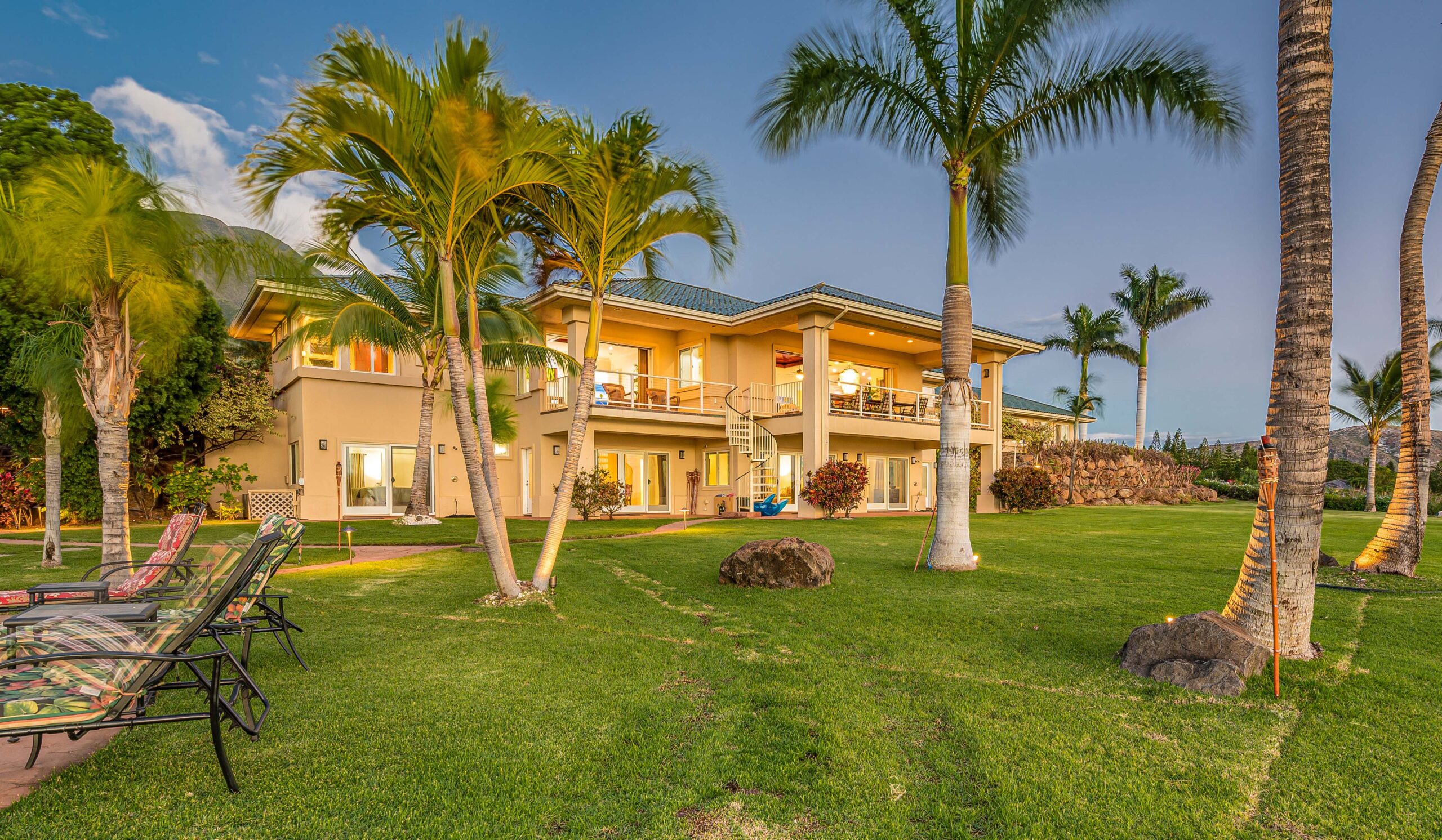 Luxury residential treatment estate with expansive lawn and tropical landscaping