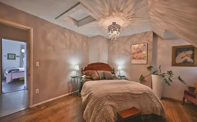 Warm bedroom with wood floors and chandelier